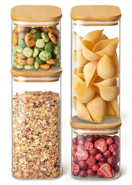 Set of glass storage jars with wooden lids containing various food items on a white background
