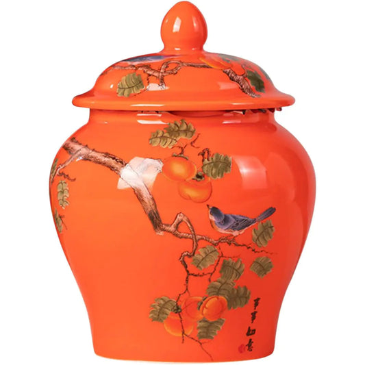 Orange ceramic jar with bird and fruit design on a white background